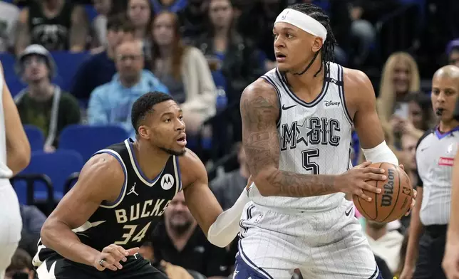 Orlando Magic forward Paolo Banchero (5) looks to pass the ball as Milwaukee Bucks forward Giannis Antetokounmpo (34) defends during the first half of an NBA basketball game, Friday, Jan. 10, 2025, in Orlando, Fla. (AP Photo/John Raoux)