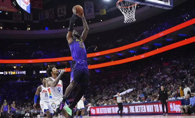 Los Angeles Lakers forward LeBron James (23) goes up for a dunk past Philadelphia 76ers' Kelly Oubre Jr. (9) during the first half of an NBA basketball game, Tuesday, Jan. 28, 2025, in Philadelphia. (AP Photo/Matt Slocum)