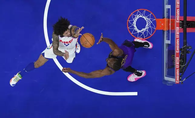 Philadelphia 76ers' Kelly Oubre Jr., left, goes up for a shot against Los Angeles Lakers' Christian Koloko during the first half of an NBA basketball game, Tuesday, Jan. 28, 2025, in Philadelphia. (AP Photo/Matt Slocum)