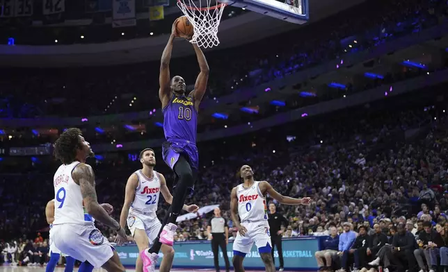 Los Angeles Lakers' Christian Koloko (10) goes up for a dunk past Philadelphia 76ers' Kelly Oubre Jr. (9), Pete Nance (22) and Tyrese Maxey (0) during the first half of an NBA basketball game, Tuesday, Jan. 28, 2025, in Philadelphia. (AP Photo/Matt Slocum)