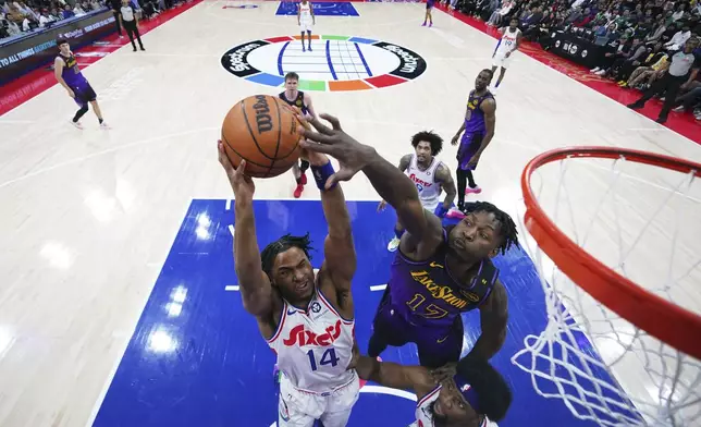Philadelphia 76ers' Ricky Council IV (14) goes up for a shot against Los Angeles Lakers' Dorian Finney-Smith (17) during the first half of an NBA basketball game, Tuesday, Jan. 28, 2025, in Philadelphia. (AP Photo/Matt Slocum)