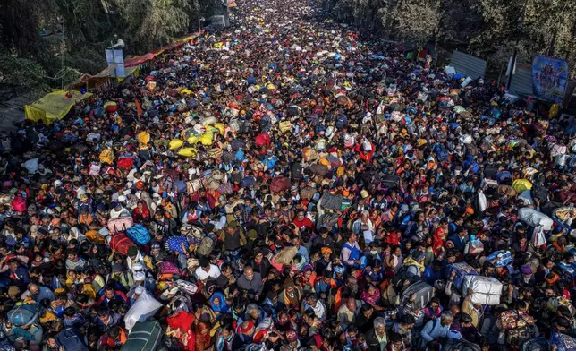 Indian Hindu devotees arrive for a holy dip at Sangam, the confluence of the Ganges, the Yamuna and the mythical Saraswati rivers, on the eve of the 'Mauni Amavasya' or new moon day during the Maha Kumbh festival, in Prayagraj, Uttar Pradesh, India, Tuesday, Jan. 28, 2025. (AP Photo/Rajesh Kumar Singh)