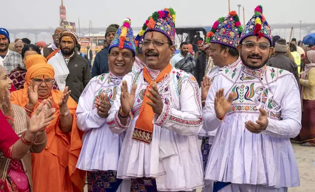 Hindu devotees wearing the ceremonial costume of the Kathiawar region in Gujarat state, sing hymns at the confluence of the Ganges, the Yamuna and the mythical Saraswati rivers, a day before the official beginning of the 45-day-long Maha Kumbh festival, in Prayagraj, India, Sunday, Jan. 12, 2025. (AP Photo/Ashwini Bhatia)