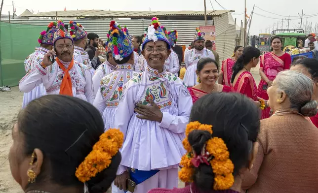 Hindu devotees wearing the ceremonial costume of the Kathiawar region in Gujarat state, sing hymns at the confluence of the Ganges, the Yamuna and the mythical Saraswati rivers, a day before the official beginning of the 45-day-long Maha Kumbh festival, in Prayagraj, India, Sunday, Jan. 12, 2025. (AP Photo/Ashwini Bhatia)