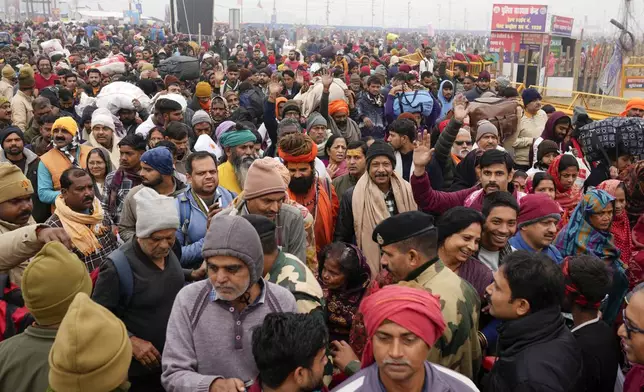 Devotees arrive for taking a dip at the confluence of the Ganges, the Yamuna and the mythical Saraswati rivers on the first day of the 45-day-long Maha Kumbh festival in Prayagraj, India, Monday, Jan. 13, 2025. (AP Photo/Rajesh Kumar Singh)