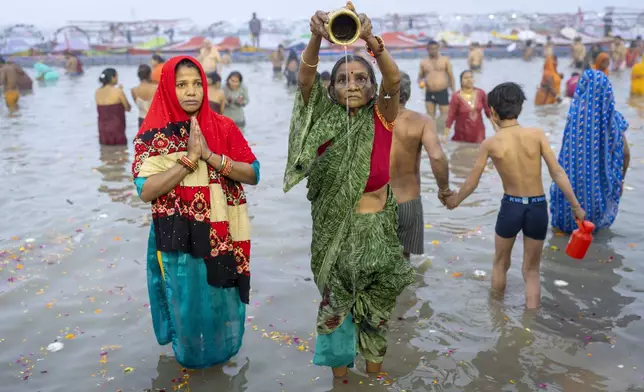 Hindu devotees pray before taking a dip at the confluence of the Ganges, the Yamuna and the mythical Saraswati rivers on the first day of the 45-day-long Maha Kumbh festival in Prayagraj, India, Monday, Jan. 13, 2025. (AP Photo/Ashwini Bhatia)