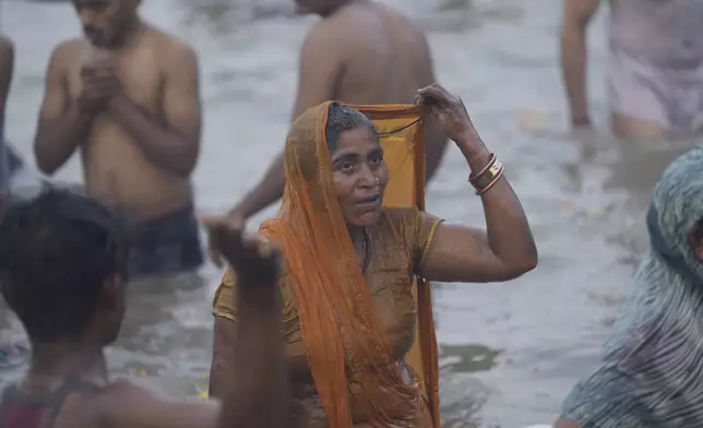 Hindu devotees take a holy dip by the banks of the Sangam, the confluence of the Ganges, the Yamuna and the mythical Saraswati rivers, on "Mauni Amavasya" or new moon day during the Maha Kumbh festival in Prayagraj, Uttar Pradesh, India, Wednesday, Jan. 29, 2025. (AP Photo/Deepak Sharma)