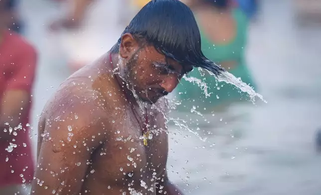 A Hindu devotee takes a holy dip in the Sangam, the confluence of the Ganges, the Yamuna and the mythical Saraswati rivers, on "Mauni Amavasya" or new moon day during the Maha Kumbh festival in Prayagraj, Uttar Pradesh, India, Wednesday, Jan. 29, 2025. (AP Photo/Deepak Sharma)