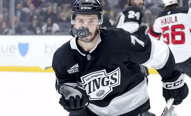 Los Angeles Kings defenseman Kyle Burroughs controls the puck during the first period of an NHL hockey game against the New Jersey Devils Wednesday, Jan. 1, 2025 in Los Angeles.