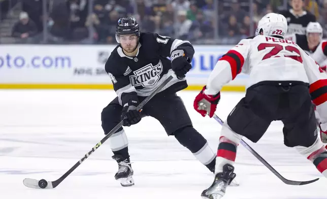 Los Angeles Kings right wing Alex Laferriere, left, skates against New Jersey Devils defenseman Brett Pesce during the second period of an NHL hockey game, Wednesday, Jan. 1, 2025, in Los Angeles. (AP Photo/Ryan Sun)