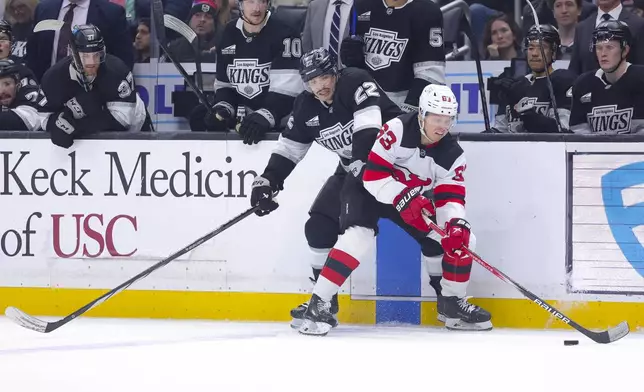 New Jersey Devils left wing Jesper Bratt, right, and Los Angeles Kings left wing Kevin Fiala vie for the puck during the second period of an NHL hockey game, Wednesday, Jan. 1, 2025, in Los Angeles. (AP Photo/Ryan Sun)