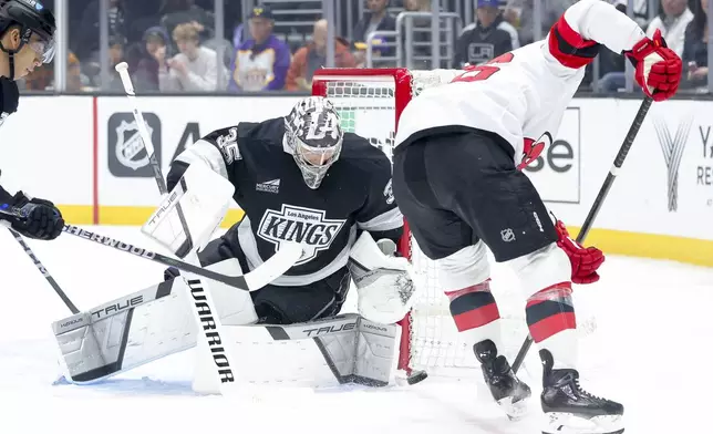 Los Angeles Kings goaltender Darcy Kuemper, left, saves a shot from New Jersey Devils left wing Erik Haula during the first period of an NHL hockey game Wednesday, January 1, 2024 in Los Angeles.