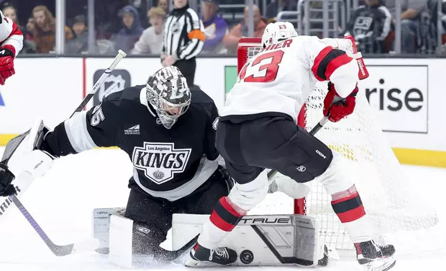 Los Angeles Kings goaltender Darcy Kuemper saves a shot from New Jersey Devils center Nico Hischier during the first period of an NHL hockey game Wednesday, Jan. 1, 2025 in Los Angeles.