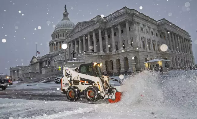 Workers clear the plaza at the Capitol as snow falls ahead of a joint session of Congress to certify the votes from the Electoral College in the presidential election, in Washington, Monday, Jan. 6, 2025. (AP Photo/J. Scott Applewhite)