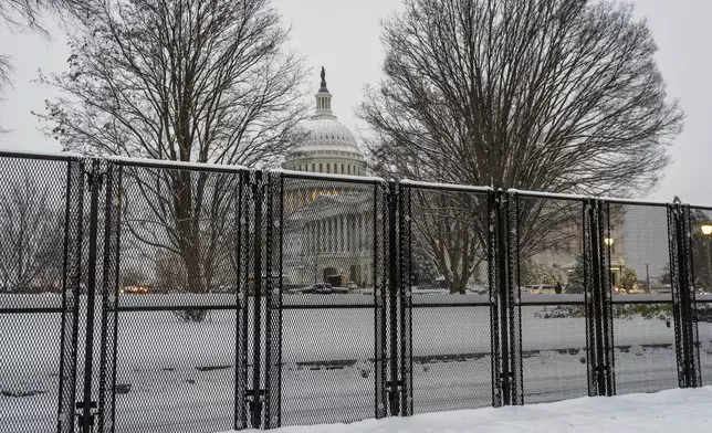 Security fencing surrounds Capitol Hill as snow blankets the region ahead of a joint session of Congress to certify the votes from the Electoral College in the presidential election, in Washington, Monday, Jan. 6, 2025. (AP Photo/J. Scott Applewhite)