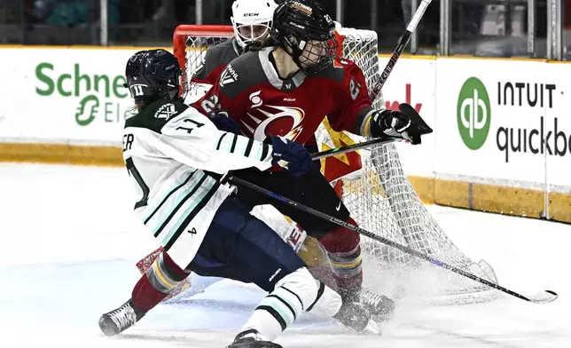 Ottawa Charge's Jocelyne Larocque, center, forces Boston Fleet's Alina Muller (11) out of position in front of Charge goaltender Gwyneth Philips, back left, during overtime PWHL hockey game action in Ottawa, Ontario, Saturday, Jan. 11, 2025. (Justin Tang/The Canadian Press via AP)