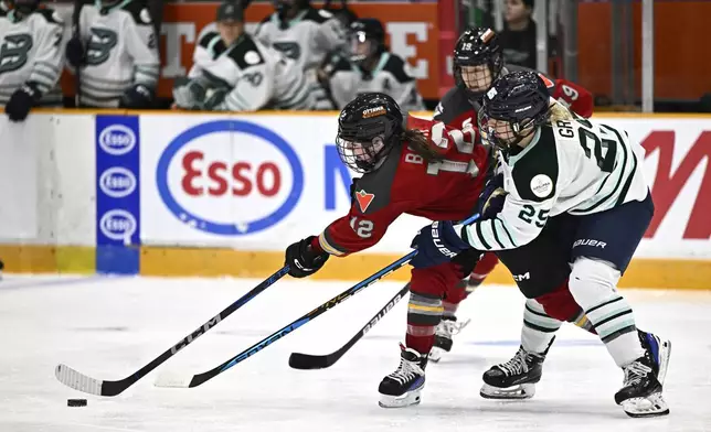 Ottawa Charge's Victoria Bach (12) tries to maintain possession against Boston Fleet's Emma Greco (25) during the third period of a PWHL hockey game in Ottawa, Ontario, Saturday, Jan. 11, 2025. (Justin Tang/The Canadian Press via AP)