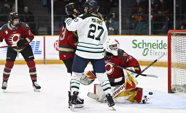 Ottawa Charge goaltender Gwyneth Philips, right, watches as the puck bounces out of the net on a goal by Boston Fleet's Sidney Morin (not shown) during overtime PWHL hockey game action in Ottawa, Ontario, Saturday, Jan. 11, 2025. (Justin Tang/The Canadian Press via AP)