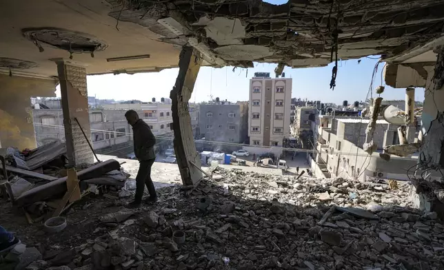 A Palestinian looks at a damaged residential building following an overnight Israeli strike in Deir al-Balah, Gaza Strip, Wednesday, Jan. 8, 2025. (AP Photo/Abdel Kareem Hana)