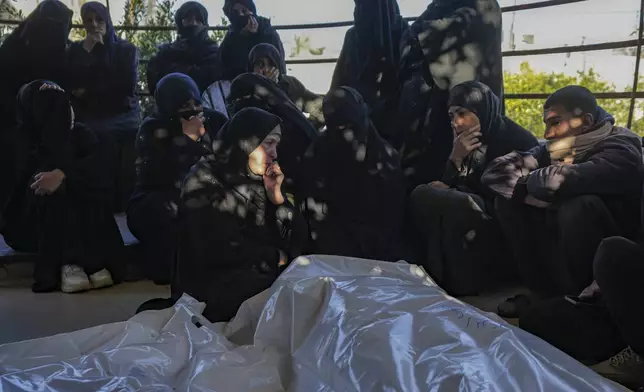 Palestinians react next to the bodies of their relatives who were killed in the Israeli bombardment of the Gaza Strip at Al-Aqsa Hospital in Deir Al-Balah, Wednesday, Jan. 8, 2025. (AP Photo/Abdel Kareem Hana)