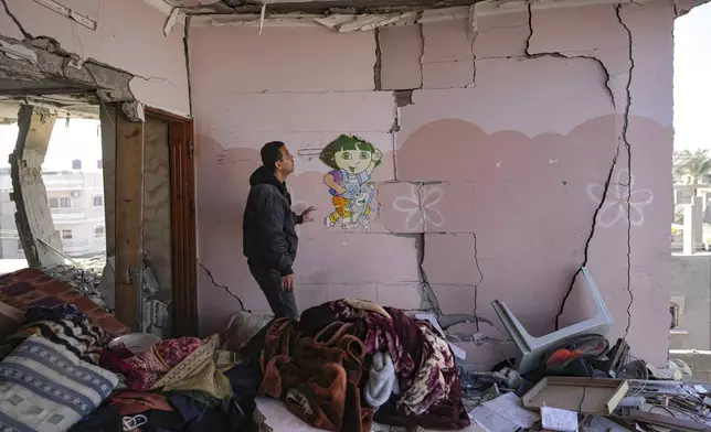 A Palestinian looks at a damaged residential building following an overnight Israeli strike in Deir al-Balah, Gaza Strip, Wednesday, Jan. 8, 2025. (AP Photo/Abdel Kareem Hana)