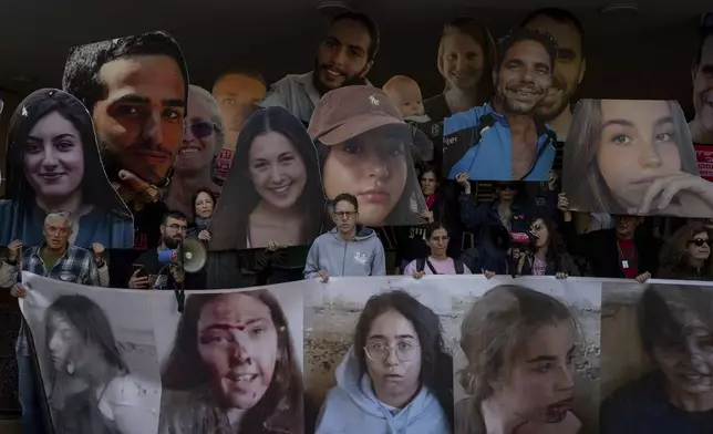 Relatives and supporters of Israeli hostages held by Hamas in Gaza hold photos of their loved ones during a protest calling for their return, in Tel Aviv, Israel, Wednesday, Jan. 8, 2025. (AP Photo/Ohad Zwigenberg)