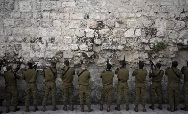 Israeli Defense Forces paratroopers clear ammunition from their weapons before entering the Western Wall plaza in Jerusalem's Old City for a ceremony on Wednesday, Jan. 8, 2025. (AP Photo/Maya Alleruzzo)