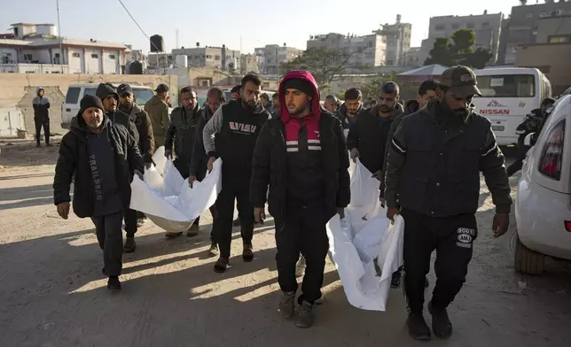 Mourners carry the bodies of their relatives killed in the Israeli bombardment of the Gaza Strip, during their funeral at Al-Aqsa Martyrs Hospital in Deir al-Balah, Wednesday, Jan. 8, 2025. (AP Photo/Abdel Kareem Hana)