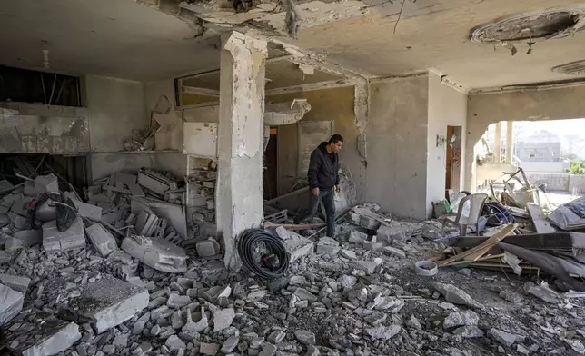 A Palestinian looks at a damaged residential building following an overnight Israeli strike in Deir al-Balah, Gaza Strip, Wednesday, Jan. 8, 2025. (AP Photo/Abdel Kareem Hana)