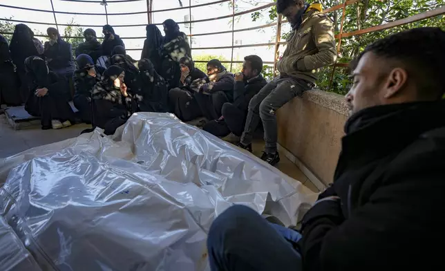 Palestinians react next to the bodies of their relatives who were killed in the Israeli bombardment of the Gaza Strip, at Al-Aqsa Hospital in Deir Al-Balah, Wednesday, Jan. 8, 2025. (AP Photo/Abdel Kareem Hana)