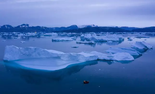 FILE - A boat navigates large icebergs near the town of Kulusuk, in eastern Greenland, on Aug. 15, 2019. (AP Photo/Felipe Dana, File)