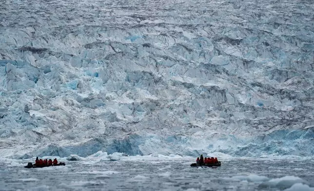 FILE - Two groups from the Poseidon Expeditions tour company look at a glacier in the Scoresby Sund, on Sept. 7, 2023, in Greenland. (AP Photo/Chris Szagola, File)