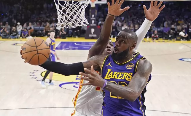 Los Angeles Lakers forward LeBron James, right, shoots as Atlanta Hawks forward Onyeka Okongwu defends during the second half of an NBA basketball game, Friday, Jan. 3, 2025, in Los Angeles. (AP Photo/Mark J. Terrill)