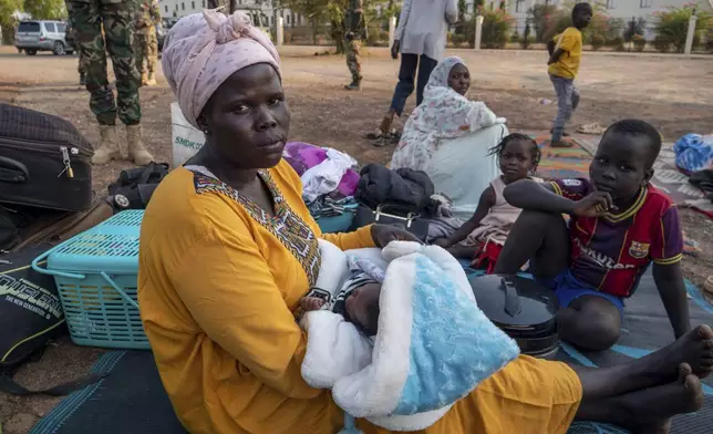 Khatmallah Ali, 30, a South Sudanese whose husband is from Sudan's western Darfur region, holds her one month old baby under a tree with her three other children, at the South Sudan People's Defense Forces (SSPDF) headquarters in Juba, South Sudan, on Friday, Jan. 17, 2025. (AP Photo/Florence Miettaux)