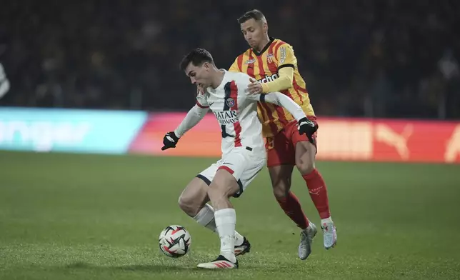 PSG's Fabian Ruiz, left, and Lens' Przemyslaw Frankowski fight for the ball during the French League One soccer match between Lens and Paris Saint-Germain, at the Bollaert-Delelis stadium in Lens, France, Saturday, Jan. 18, 2025. (AP Photo/Thibault Camus)
