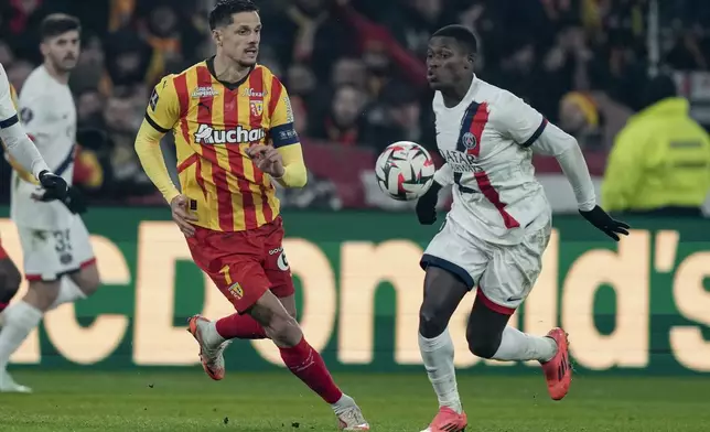 Lens' Florian Sotoca, left, and PSG's Nuno Mendes fight for the ball during the French League One soccer match between Lens and Paris Saint-Germain, at the Bollaert-Delelis stadium in Lens, France, Saturday, Jan. 18, 2025. (AP Photo/Thibault Camus)