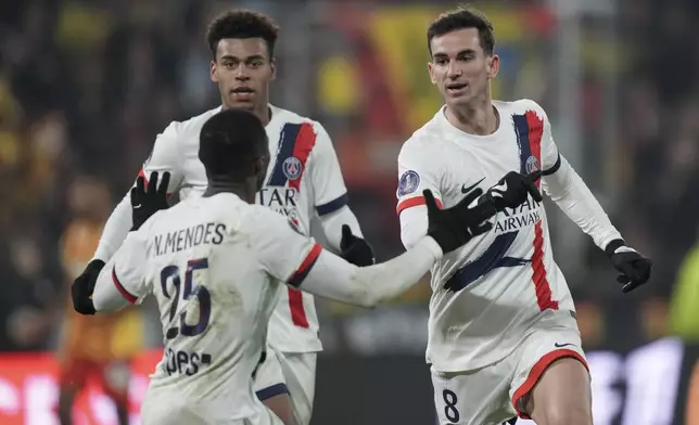 PSG's Fabian Ruiz, right, celebrates with his teammates after he scored his side's first goal during the French League One soccer match between Lens and Paris Saint-Germain, at the Bollaert-Delelis stadium in Lens, France, Saturday, Jan. 18, 2025. (AP Photo/Thibault Camus)