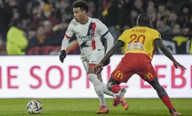 PSG's Desire Doue, left, and Lens' Malang Sarr fight for the ball during the French League One soccer match between Lens and Paris Saint-Germain, at the Bollaert-Delelis stadium in Lens, France, Saturday, Jan. 18, 2025. (AP Photo/Thibault Camus)