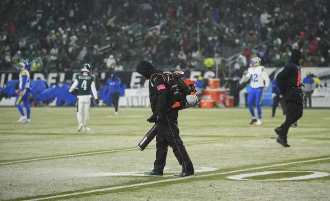 Snow is cleared as the first half ends of an NFL football NFC divisional playoff game between the Philadelphia Eagles and the Los Angeles Rams on Sunday, Jan. 19, 2025, in Philadelphia. (AP Photo/Matt Slocum)