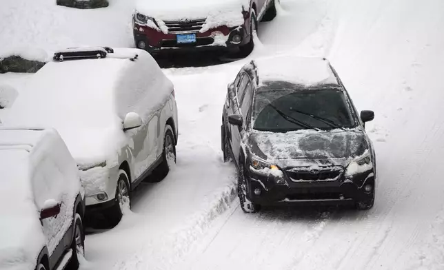 A motorist struggles to move along Pearl Street as a winter storm sweeps over the intermountain West, plunging temperatures into the single digits and bringing along a light snow in its wake Saturday, Jan. 18, 2025, in Denver. (AP Photo/David Zalubowski)