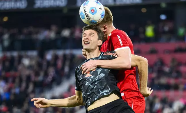 Munich's Thomas Müller, left, and Freiburg's Philipp Lienhart in action during the Bundesliga soccer match between SC Freiburg and Bayern Munich at Europa-Park Stadium, Freiburg, Germany, Saturday Jan. 25, 2025. (Tom Weller/dpa via AP)