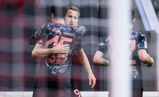 Munich's Harry Kane, center, celebrates scoring during the Bundesliga soccer match between SC Freiburg and Bayern Munich at Europa-Park Stadium, Freiburg, Germany, Saturday Jan. 25, 2025. (Tom Weller/dpa via AP)