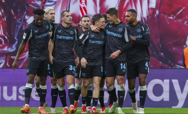 Leverkusen's players gahter around goal scorer Patrik Schick to celebrate a goal during the German Bundesliga soccer match between RB Leipzig and Bayer 04 Leverkusen in Leipzig, Germany, on Saturday, Jan. 25, 2025. (Jan Woitas/dpa via AP)