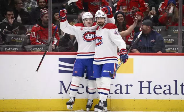 Montreal Canadiens right wing Cole Caufield, left, celebrates his goal with defenseman Alexandre Carrier, right, during the second period of an NHL hockey game against the Washington Capitals, Friday, Jan. 10, 2025, in Washington. (AP Photo/Nick Wass)