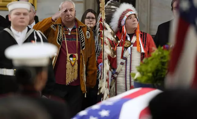 Army veteran Donald Woody, left, and Marine veteran Warren Stade, in eagle feather bonnet, pay their respects as former President Jimmy Carter lies in state at the U.S. Capitol, Wednesday, Jan. 8, 2025, in Washington. Carter died Dec. 29 at the age of 100. The two are from the Skakopee Mdewakanton Sioux Community in Prior Lake, Minn. (AP Photo/Steve Helber)