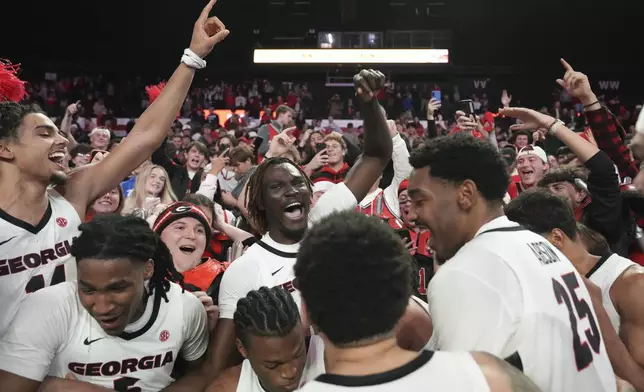 The Georgia basketball team celebrates with the University of Georgia students after a win against Kentucky at an NCAA college basketball game, Tuesday, Jan. 7, 2025, in Athens, Ga. (AP Photo/Brynn Anderson)