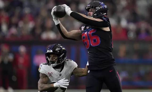 Houston Texans tight end Dalton Schultz (86) catches a pass over Baltimore Ravens safety Ar'Darius Washington (29) during the first half of an NFL football game, Wednesday, Dec. 25, 2024, in Houston. (AP Photo/David J. Phillip)