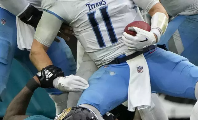 Tennessee Titans quarterback Mason Rudolph (11) is sacked by Jacksonville Jaguars defensive end Josh Hines-Allen (41) during the second half of an NFL football game Sunday, Dec. 29, 2024, in Jacksonville, Fla. (AP Photo/John Raoux)