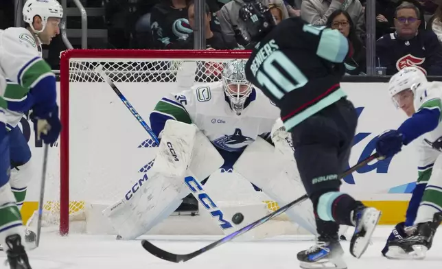 Vancouver Canucks goaltender Thatcher Demko saves a shot against Seattle Kraken center Matty Beniers (10) during the first period of an NHL hockey game Thursday, Jan. 2, 2025, in Seattle. (AP Photo/Lindsey Wasson)