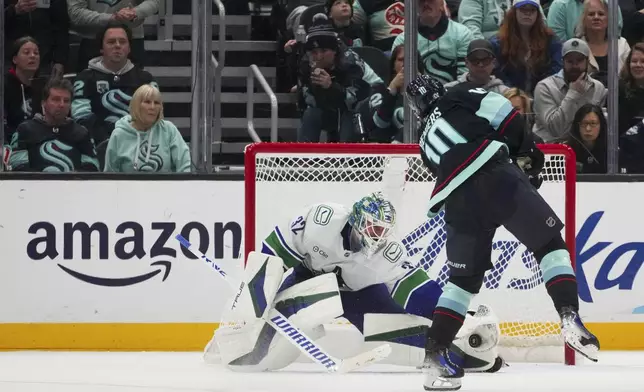 Vancouver Canucks goaltender Kevin Lankinen makes a save against Seattle Kraken center Matty Beniers (10) during a shootout for a 4-3 Canucks win in an NHL hockey game Thursday, Jan. 2, 2025, in Seattle. (AP Photo/Lindsey Wasson)